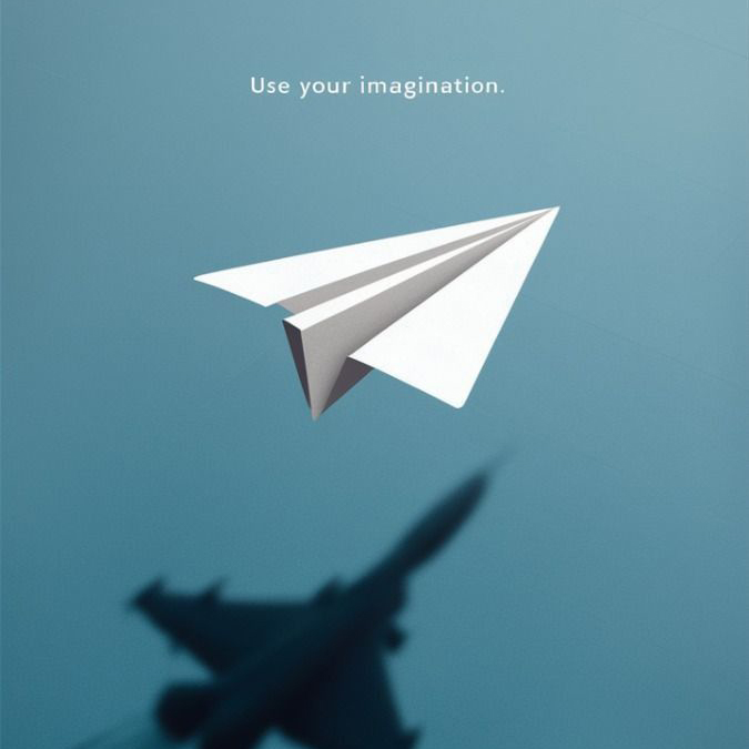 Avion en papier projetant l'ombre d'un avion de ligne, avec la mention « Use your imagination »