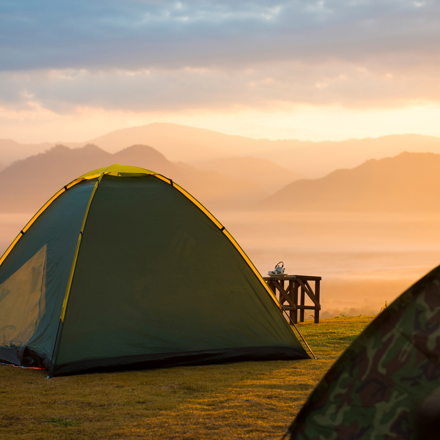 Tente de bivouac face aux montagnes au lever du jour : choisir son itinéraire de communication